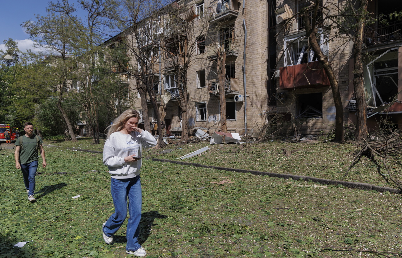 Un homme et une femme devant un bâtiment détruit