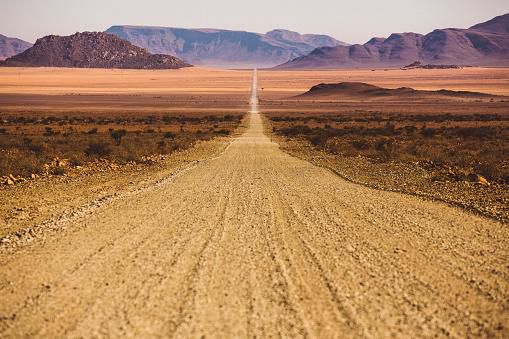 Route poussiéreuse vide en Namibie s'étendant droit dans l'infini