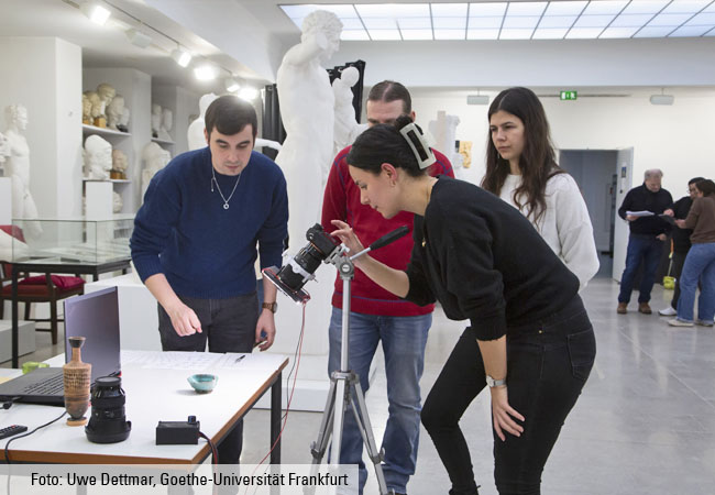 Quatre étudiants photographient un petit vase.
