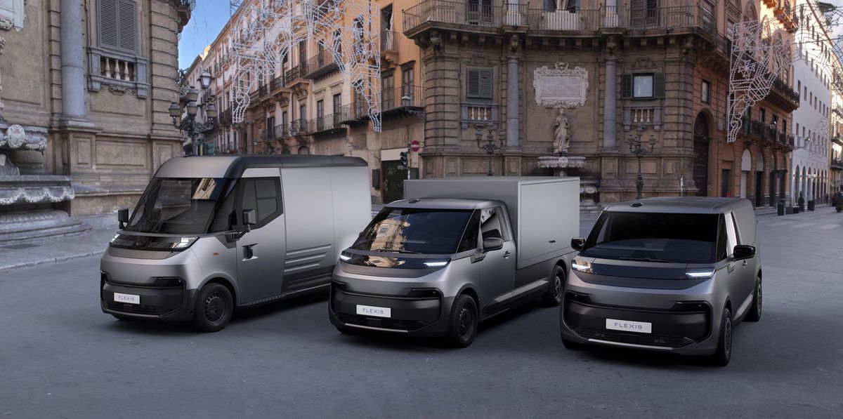 Trois fourgonnettes futuristes dans une rue de ville européenne devant des bâtiments historiques.