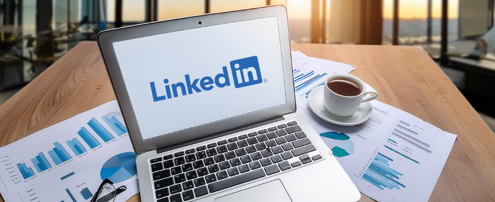 Bureau avec un ordinateur portable affichant le logo LinkedIn